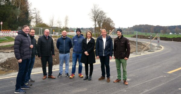 Das Bild zeigt Landrat Hans Reichhart, Henrik Vosdellen (Staatliches Bauamt), Alexander Leis (Staatliches Bauamt), Thomas Schweizer (Staatliches Bauamt), Manuel Goldau (Kranzfelder Bau), Landtagsabgeordnete Jenny Schack, Bürgermeister Christoph Böhm und Johannes Rauner (Regierung von Schwaben) bei der Krebsgrabenbrücke.